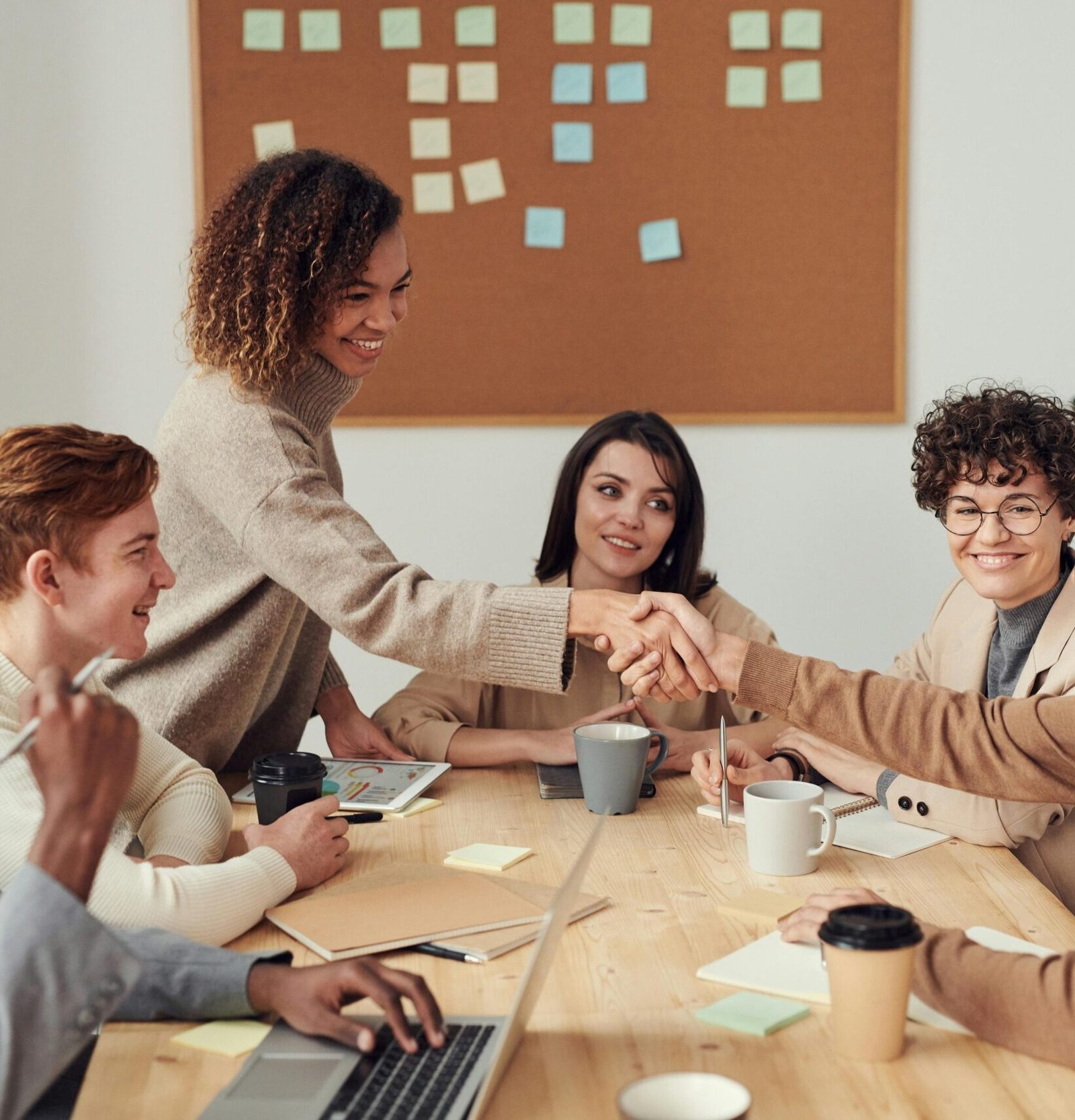 Diverse team collaborating in a meeting, showcasing teamwork and cooperation in a modern workplace.